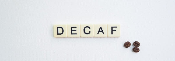Letras de intelect con la palabra DECAF y unos granos de café