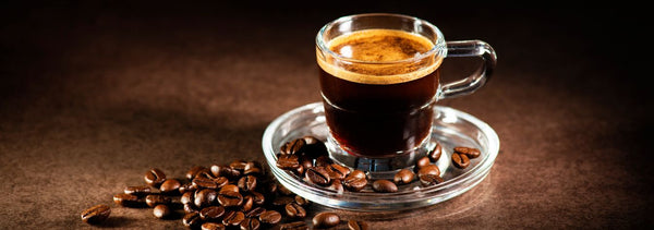 Taza de café solo recién hecho, rodeada de granos de café